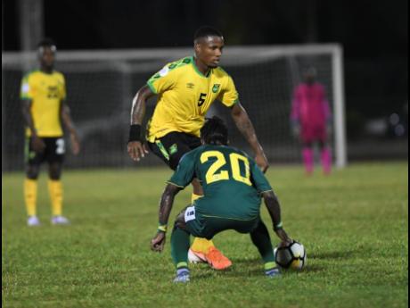 Jamaica’s Alvas Powell tries to move past Guyana’s Trayon Bobb in their Nations League encounter last Monday. 