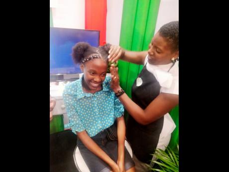 A customer tries out products at the National Hairdresser Association conference held at The Jamaica Pegasus hotel in Kingston yesterday.