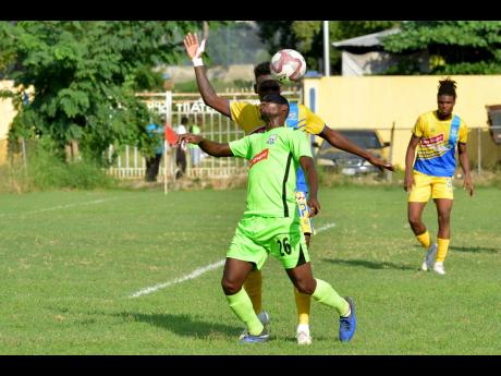 Harbour View’s Damion Thomas engages Molynes United’s Romario Campbell (front) in an aerial battle for possession in their Red Stripe Premier League game at the Constant Spring field yesterday.