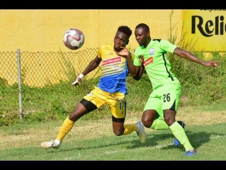 Harbour View’s Damion Thomas (left) battles with Molynes United’s Romario Campbell in their Red Stripe Premier League match at the Constant Spring football field on Wednesday.
