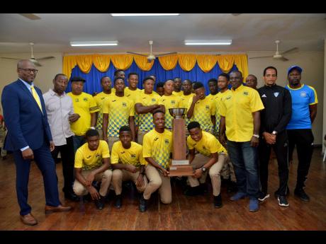 Members of the daCosta Cup champions, Clarendon College, celebrate with their principal David Wilson (left) and members of the coaching staff at the school on Monday.