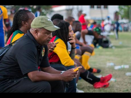 Lenny Hyde (left) sits on the bench of Falmouth United, along with owner Ky-mani Marley, during a Western Confederation match against Montego Bay United on December 8, 2019.