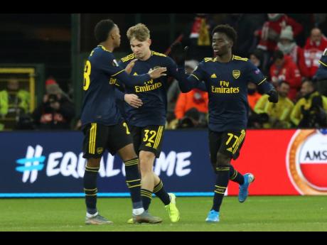 From left: Arsenal’s Joe Willock Rowe, Emile Smith and, Bukayo Saka celebrate a goal during the Europa League group F match between Standard Liege and Arsenal at the Maurice Dufrasne stadium in Liege, Belgium, yesterday.