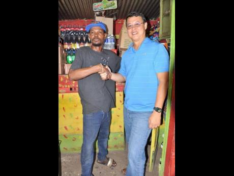 Credit: Contributed Rohan Elison (left) thanks Garth Young, operator of Young’s Pharmacy in May Pen, Clarendon. Young was one of the sponsors who assited Elison with restocking hs shop.