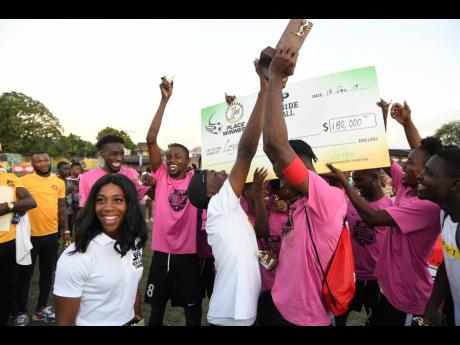 Shelly-Ann Fraser-Pryce presents the winning trophy to Legacy United at the Shelly-Ann Fraser-Pryce Six-A-Side final at Foska Oval at 451 Spanish Town Road in Kingston, yesterday.