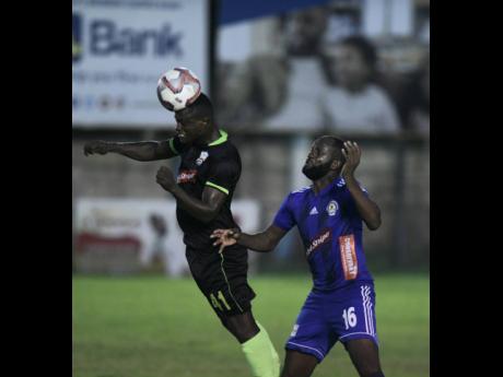 Credit: Ricardo Makyn Molynes United’s player Renaldo Smith heads the ball away from Mount Pleasant’s Francois Swaby, in their Red Stripe Premier League encounter at the Drewsland Stadium on October 6.