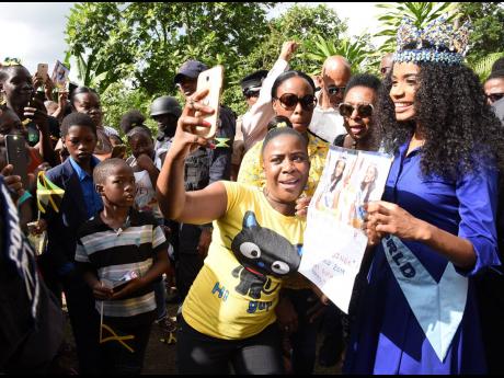 Toni-Ann Singh (right) poses for pictures with fans  in Arcadia, St Thomas, yesterday.