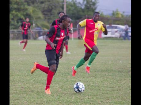 Credit: Lennox Aldred Kemal Malcolm of Arnett Gardens moves away from Humble Lion’s Gregory Lewis during their RSPL encounter at Effortville in Clarendon yesterday.