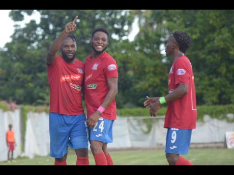 Dunbeholden’s goalscorer Dean-Andre Thomas (centre) celebrates with teammates André McFarlane (left) and Demario Phillips during their game against UWI FC in the Red Stripe Premier League at Royal Lakes in St Catherine on Sunday.