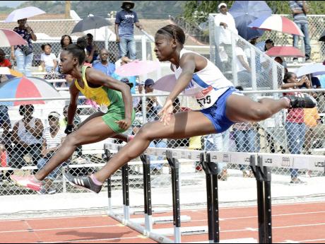 Credit: Ian Allen Rosalee Cooper (left) of St Jago High School and Hydel High’s Taffara Rose battling for top spot in a heat of the Class One Girls 100me hurdles at the Purewater/JC/Danny Williams Invitational Development Meet at Jamaica College on Saturday, January 5, 2019.