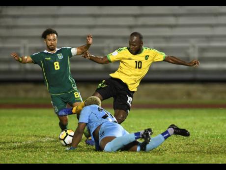 Jamaica’s Javon East (right) creates problems for Guyana defender Samuel Cox (left) and goalkeeper Quillan Roberts during a Concacaf Nations League game at the Montego Bay Sports Complex on Monday, November 18, 2019.