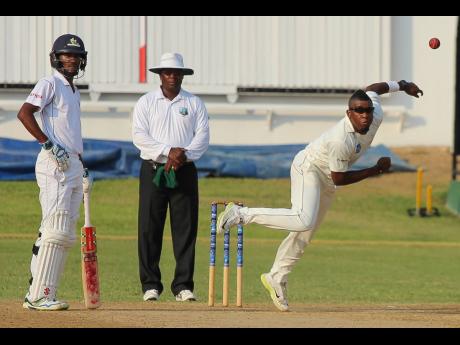 Non-striker Kraigg Brathwaite (left) and umpire Nigel Duguid watch leg-spinner Damion Jacobs (right) bowl on the first day of the eighth-round match between Jamaica Scorpions and Barbados Pride in the Cricket West Indies Professional Cricket League Regional 4-Day Tournament on Friday, February 26, 2016, at Sabina Park in Kingston.