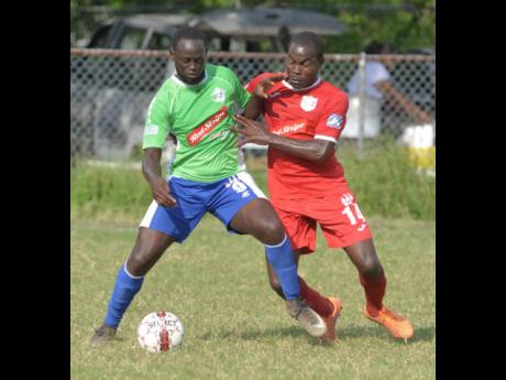 In this January 2018 file photo, Montego Bay United’s Dino Williams (left) shields Boys’ Town’s Ricardo Dennis from the ball during a Red Stripe Premier League game at the Barbican field that season.
