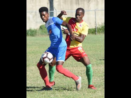 Shai Smith (left) of Portmore United shields the ball from Humble Lion’s Levaughn Williams  during their Red Stripe Premier League match at the Spanish Town Prison Oval on January 5, 2020.