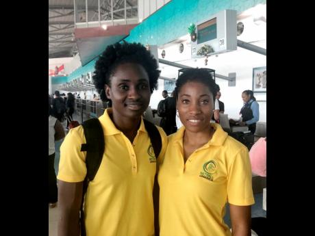 Sunshine Girls Shannika Johnson (left) and Shadian Hemmings at the Norman Manley International Airport yesterday. 