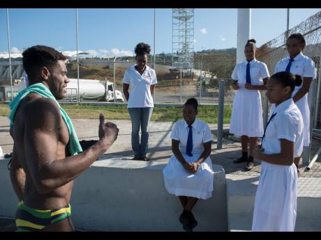 Olympian Yona Knight-Wisdom (left) shares diving advice with members of the Immaculate Conception High School swim team and Kaizen Swim Club members in between dives in a training session at the National Aquatic Centre in Kingston last Thursday January.