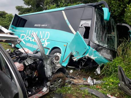 The mangled wreck of the Nissan March motor car and Island Routes King Long bus that collided along the North Coast Highway in Trelawny, where four persons died.