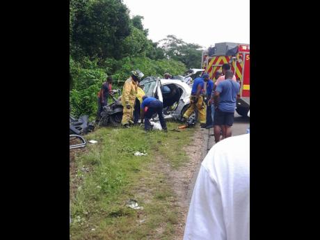 Firemen from Trelawny extricating Alecia Greenwood from The Nissan March involved in an accident, where four persons died.