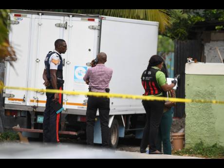 Police personnel on the scene of the  shooting death of 18-year-old Lavern Edwards on Escarpment Road, August Town, yesterday.