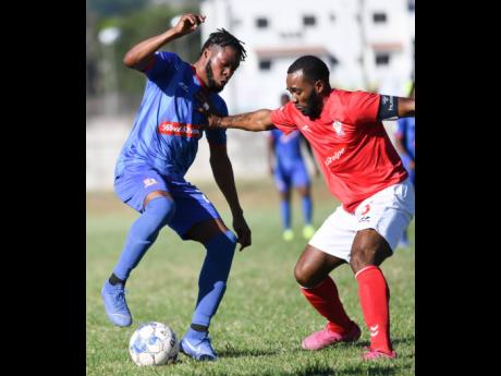 Dunbeholden’s Deandre Thomas (left) taking on  UWI FC’s  Fabion McCarthy  during their  Red Stripe Premier League encounter at the UWI Bowl on Sunday, January 12.