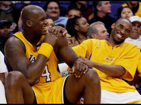 FILE - In this April 15, 2003, file photo, Los Angeles Lakers Shaquille O’Neal, left, and Kobe Bryant share a laugh on the bench while their teammate take on the Denver Nuggets during the fourth quarter at Staples Center in Los Angeles. 