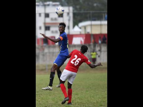 Molynes United’s Nicholas Nelson (left) heads the ball away from UWI’s Javoy Blenavis in their Red Stripe Premier League encounter at the UWI Mona Bowl on Sunday.
