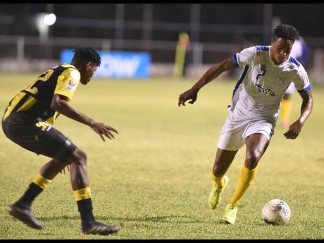 Waterhouse’s Stephen Williams (right) dribbles away from Peterson Pierre (left) of Don Bosco from during their Concacaf Caribbean Club Championships match at the Anthony Spaulding Sport Complex, yesterday.