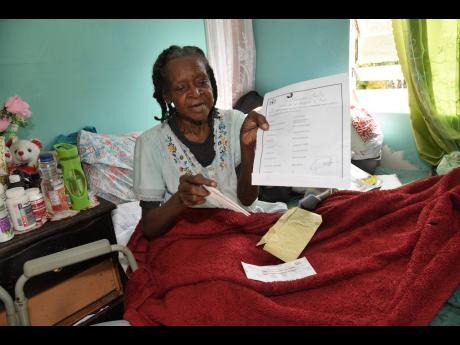 Mavis Beckford, from New Road in Clarendon, shows the deeds to her property, while lamenting that she has not been paid for lands used by the Government for the upgrading of the Chapleton main road in Clarendon.