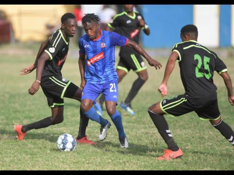 Molynes United player Jermey Nelson (left) and his teammate Orane Ferguson (right) challenge Dunbeholden’s Nickoy Christian for the ball during their Red Stripe Premier League match at the Constant Spring Football Football Field on December 29, 2019.