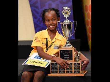 Toriann Beckford poses with The Gleaner’s Children’s Own Spelling Bee trophy after winning the national final on Wednesday.