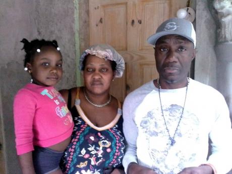 Distraught parents Shereen and Clarence Johnson stand with their four-year-old granddaugter D-Lania Arnold, whose mother, Donnia Johnson, was found dead in a male bathroom at her workplace.