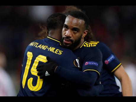 Arsenal’s Alexandre Lacazette (right), scorer of  his team’s winning goal, celebrates with teammate Ainsley Maitland-Niles after the end of a Europa League round-of-32, first leg, match against  Olympiakos in Athens, Greece.  Arsenal won 1-0. 