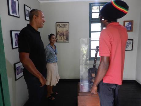 Jermaine Reid (right) speaks with tourists about the negative perception of Trench Town.