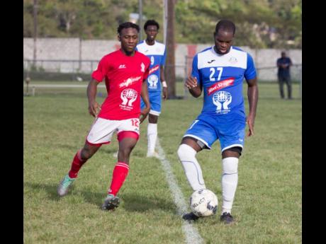 Credit: Lennox Aldred Portmore United Kevon Farguharson (right) looks for a pass as he is being hounded by UWI’s Nacquain Brown yesterday.