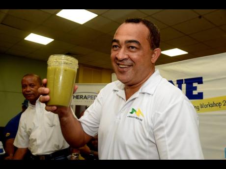 Health Minister Dr Christopher Tufton shows off his fruit and vegetable smoothie.