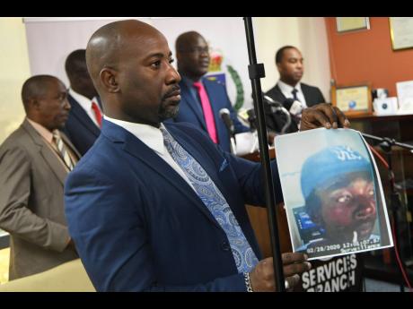 Dennis Brooks, senior communications strategist of the Jamaica Constabulary Force, shows a photo of a person of interest in the disappearance of the UWI student Jasmine Deen. 