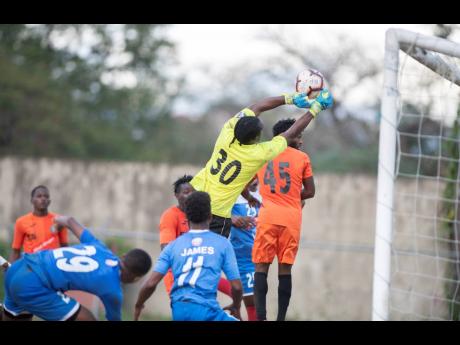 Tivoli Gardens’ goalkeeper Davian Watkins (#30) punches a corner kick clear of the goal in their Red Stripe Premier League fixture against Portmore United at the Spanish Town Prison Oval on March 1, 2020.
