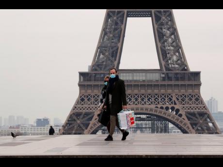 A masked couple walks on the empty Trocadero next to the Eiffel Tower, in Paris, France.