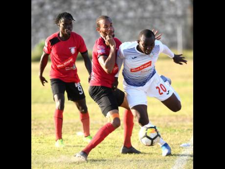 Portmore United’s Rondee Smith (right) goes past Arnett Gardens’ Jamar Martin in a Red Stripe Premier League encounter at the Prison Oval recently.