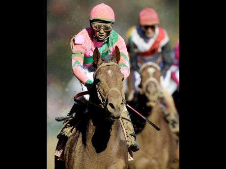 Jamaican jockey Rajiv Maragh reacts after riding Caleb’s Posse to victory in the Dirt Mile race at the Breeders’ Cup horse races at Churchill Downs in Louisville, Kentucky in 2011.
