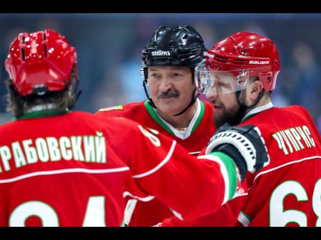 In this photo taken on Saturday, March 28, 2020, Belarusian President Alexander Lukashenko (centre) takes part in a hockey match during Republican amateur competitions in Minsk, Belarus. 