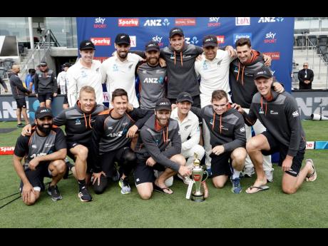 The New Zealand team posing with their trophy after winning a recent Test series against India 2-0.