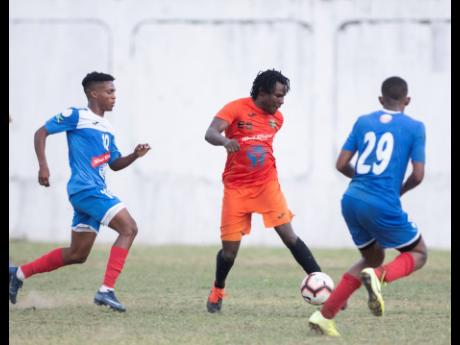 Rodico Wellington (centre) of Tivoli Gardens goes on the attack against opponents from Portmore United in the Red Stripe Premier League at Spanish Town Prison Oval earlier this season.