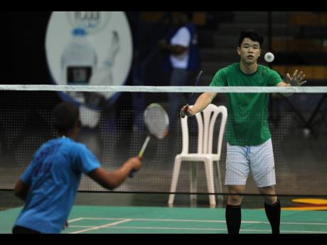 Anthony Murillo of Panama (blue) and  Matthew Lee of Jamaica  take part in a rally at the Jamaica International 2017 badminton tournament at the Indoor Sporting Centre on February 3, 2017.