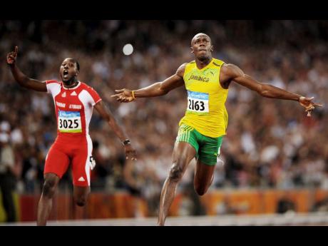 Jamaica’s Usain Bolt celebrates winning the gold medal in the men’s 100m final during at the Olympic Games at the Bird’s Nest Stadium in Beijing, China, on Saturday, August 16, 2008. At left is Trinidad’s Richard Thompson.