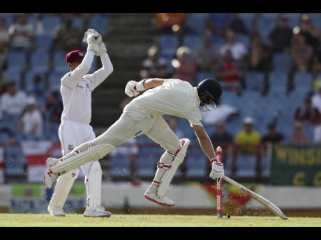 file
England’s captain Joe Root (right) steals a run against the Windies, whose wicketkeeper Shane Dowrich looks on, during day three of the third Test match at the Daren Sammy Cricket Ground in Gros Islet, St Lucia, last year.
