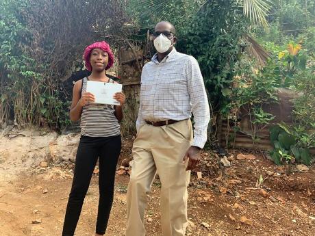 Credit: Contributed Stephen Wedderburn donates a tablet computer to Shania Knight.