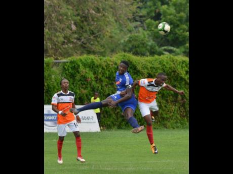 Credit: Kenyon hemans Mount Pleasant’s Ladale Richie (centre) and Dwayne Smith (right) from Dumbeholden FC goes up for a ball during their Red Stripe Premier League match on Wedneday January 16 2019.