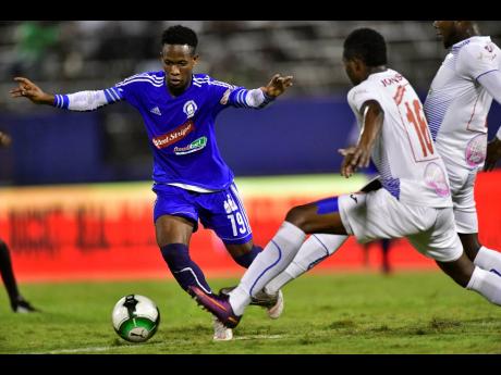 Credit: Gladstone Taylor Mount Pleasant’s Cardel Benbow weaves his way through a bevy of Portmore United players during their Red Stripe Premier League semi-final encounter against Portmore United on April 15, 2019.