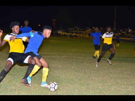 Tevoy Colespring of Meadforest FC holds off Barbican FC’s Damian English (left) during their Kingston and St Andrew Football Association/Magnum Super League first-round clash at the Constant Spring Field last season.